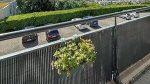 En balkong med utsikt över en motorväg, ett bergskedja och en stadsbild.