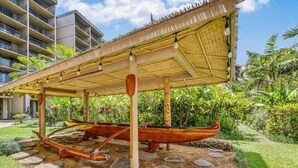 Un'area esterna riparata con barche tradizionali e un edificio sullo sfondo.