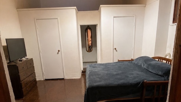 A bedroom with a bed, a wardrobe, a dresser, and a mirror. - Casa Roberto Hotel (Álamos)
