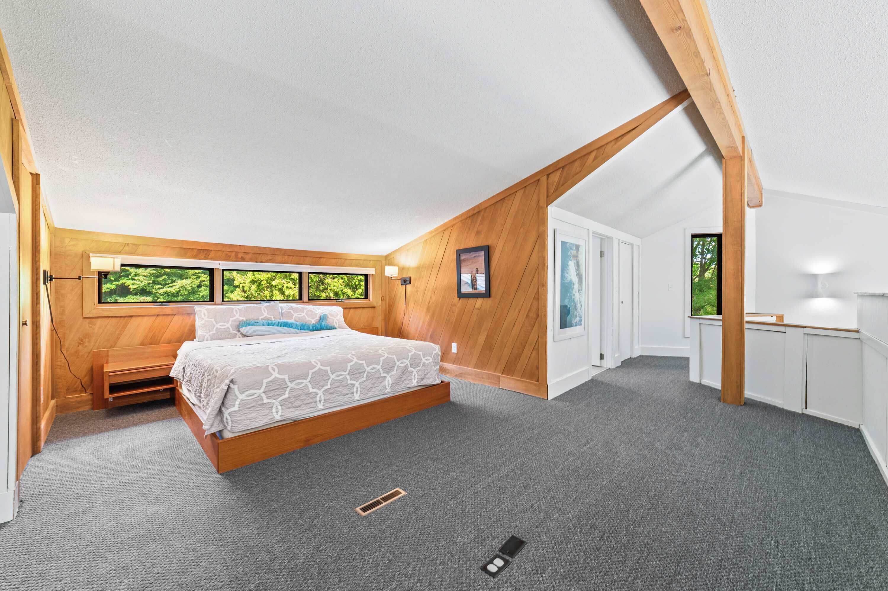 Une chambre à coucher avec un lit en bois, une fenêtre et une porte.