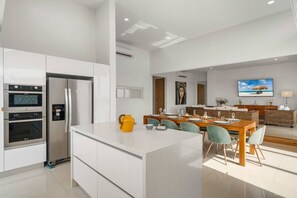 Una cocina moderna con electrodomésticos integrados y un comedor con una isla grande.