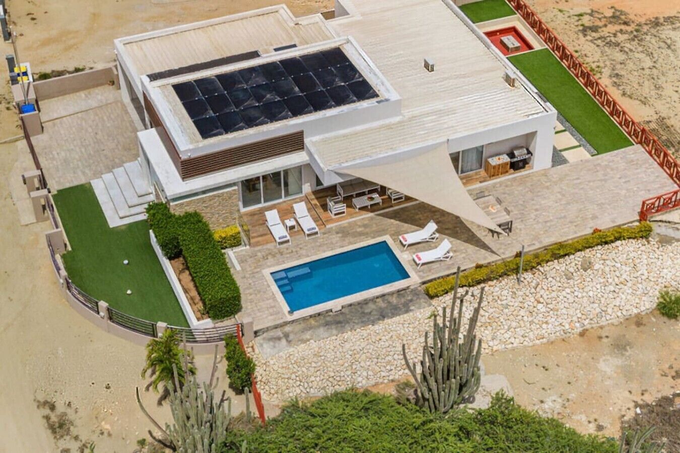 Una casa moderna con piscina, un patio cubierto y un conjunto de paneles solares.