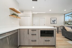 A modern kitchen with wooden cabinets, a built-in oven, and a white countertop.
