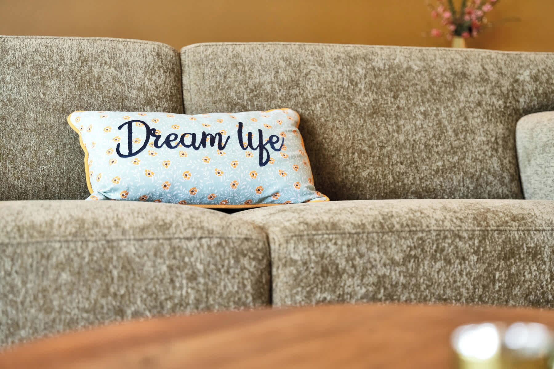 Ein Sofa mit einem Kissen, auf dem der Schriftzug 'Dream Life' steht.