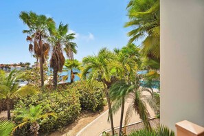 A resort with palm trees, a pool, and a clear blue sky. - Bon Bida Trupial, apartment with shared pool (Kralendijk)