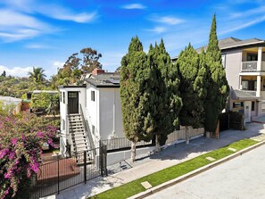 A residential area with a white house, a staircase leading to a door, and a large tree. - Hot Tub & Arcade Escape Near Balboa Park (San Diego)
