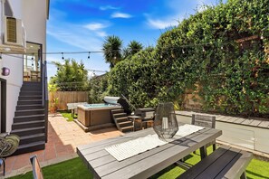 A backyard with a hot tub, outdoor seating, and a pergola. - Hot Tub & Arcade Escape Near Balboa Park (San Diego)