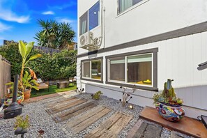Il s’agit d’une propriété résidentielle dotée d’une terrasse, d’un espace salon extérieur et d’une variété de plantes.