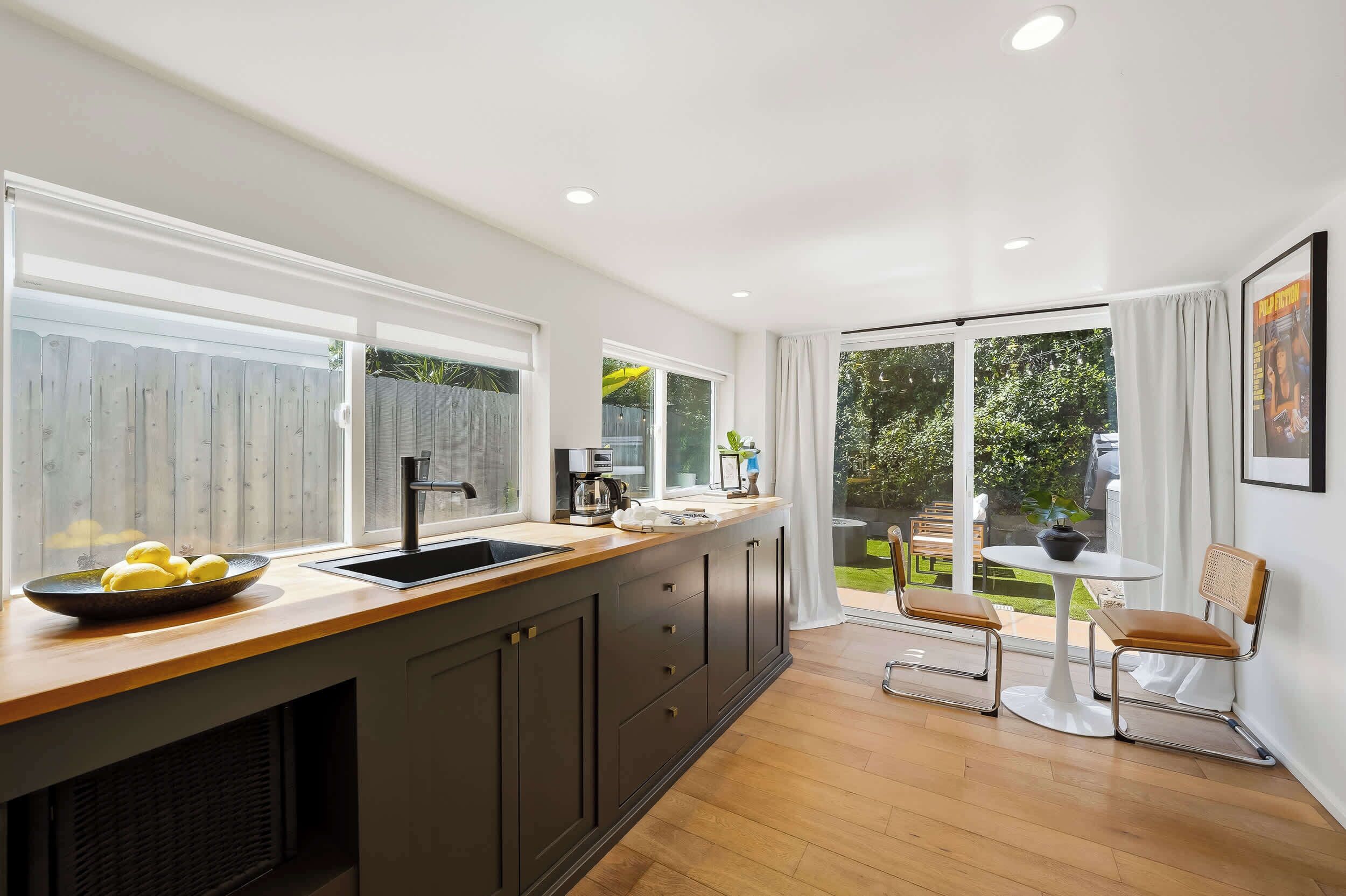 Una cocina moderna con un amplio ventanal, un comedor con mesa y sillas, y vistas al exterior.