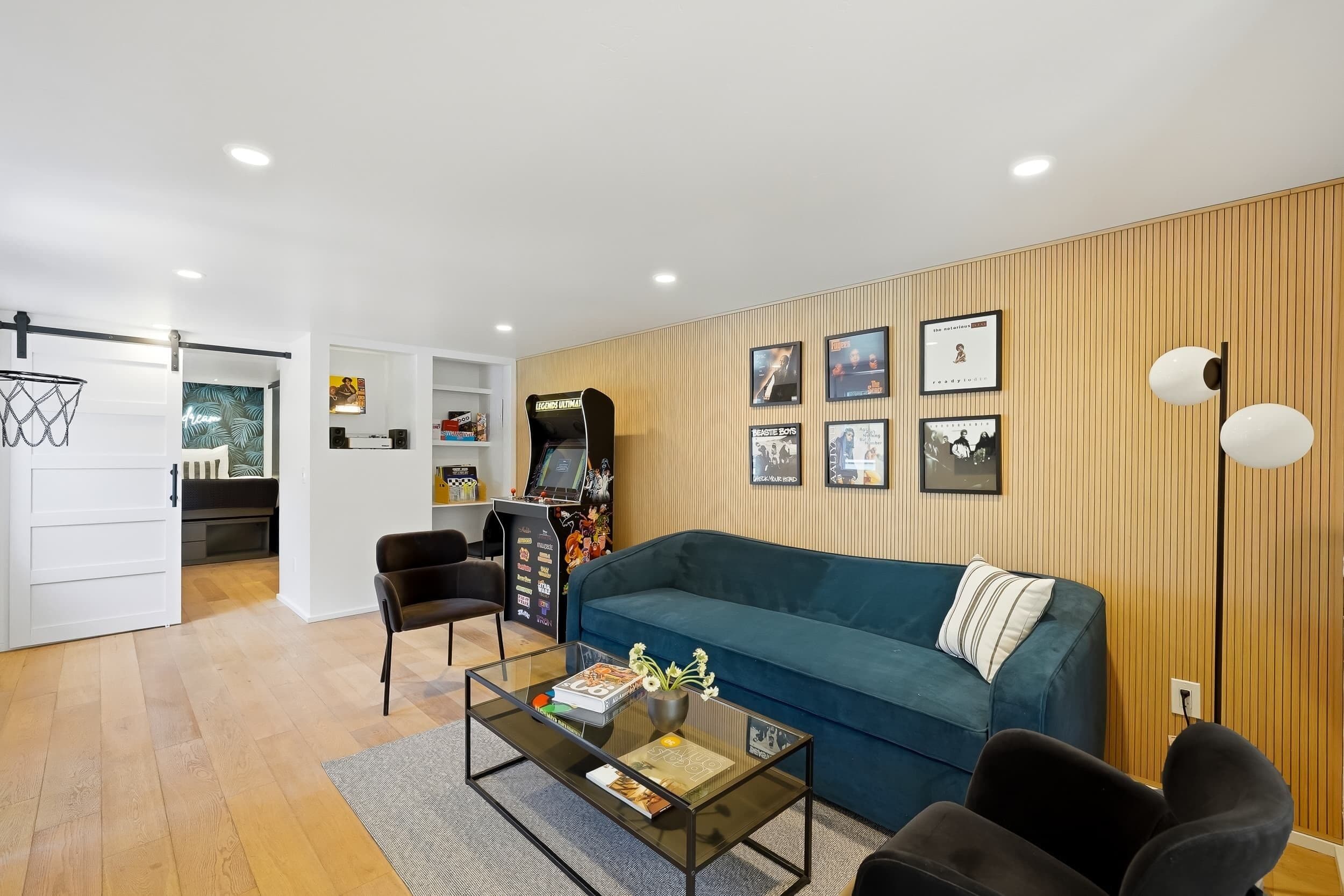 A modern living room with a blue sofa, a coffee table, and a gaming console.