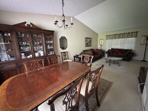 A dining area with a wooden table and chairs, a china cabinet, a sofa, and a floor lamp. - Perfect two story home 4BR, 2.5 Bath in the heart of Rancho Penasquitos. (San Diego)