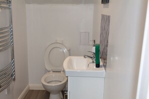 Ein kleines Badezimmer mit Toilette, Waschbecken und Handtuchhalter.