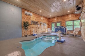 Un espace piscine avec un aménagement intérieur en bois, un panier de basketball et des fauteuils Adirondack.