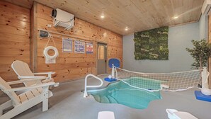 Ett poolområde med en skylt som varnar för grunt vatten, en livräddarstol och en poolvärmare.