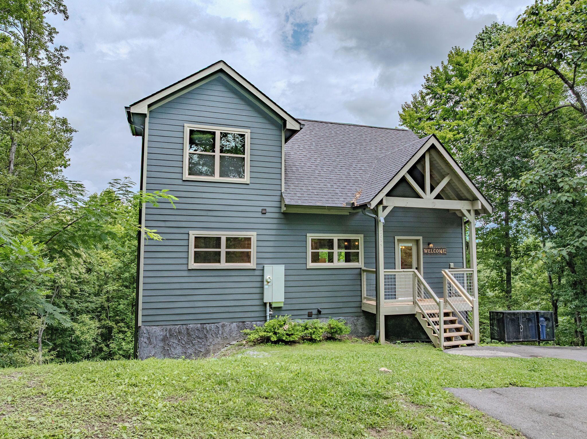 A two-story building with a porch and a staircase leading to the entrance.