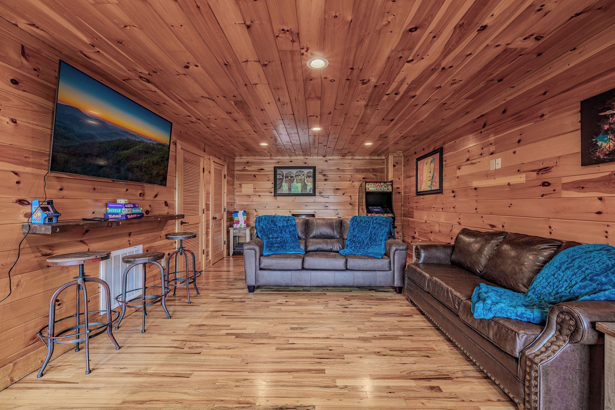 Un intérieur en bois avec un canapé, un coin bar et un tableau au mur.