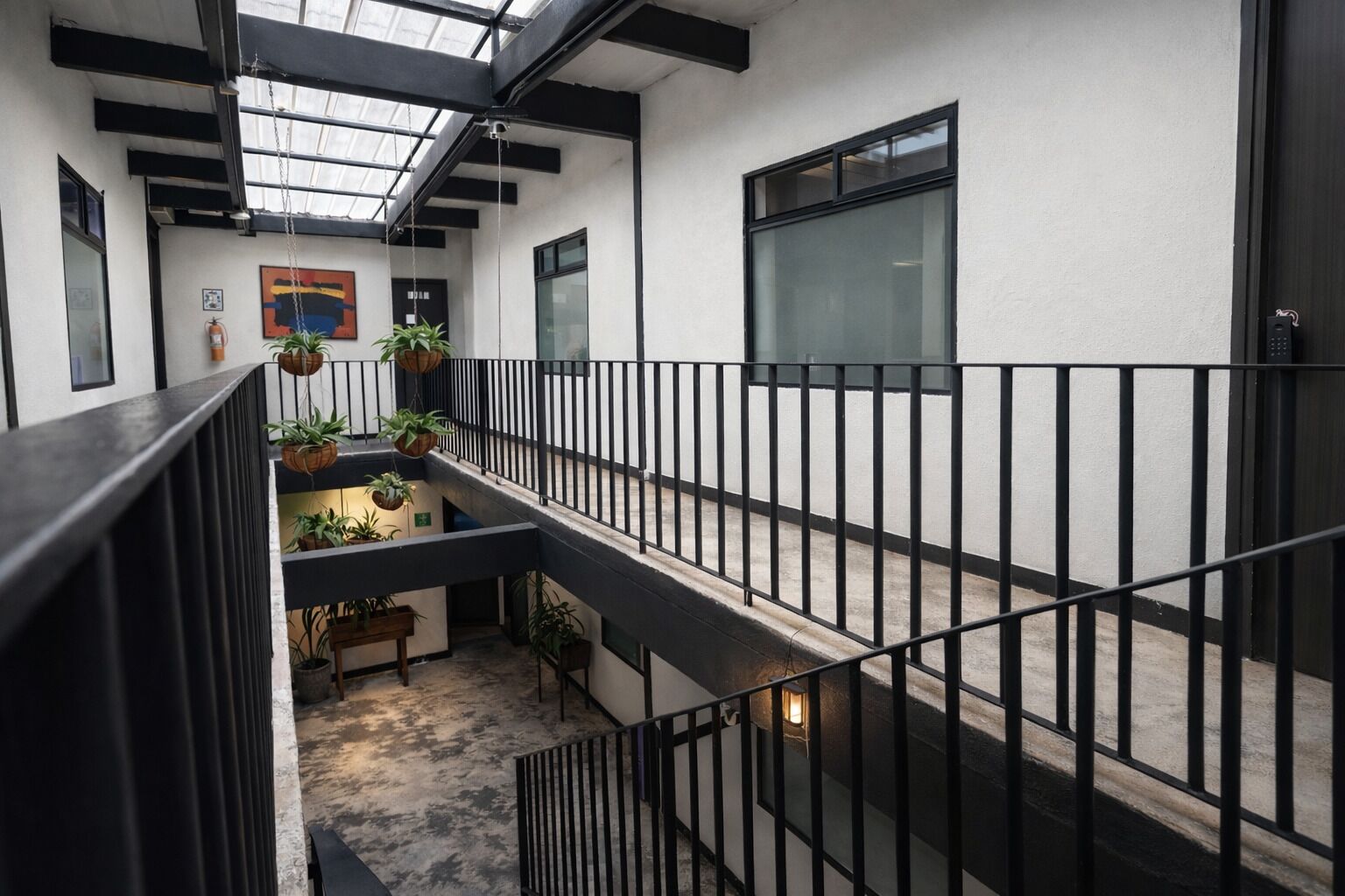 A multi-level interior with a balcony, potted plants, and a staircase.