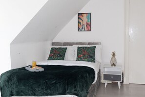 A bedroom with a bed, a nightstand, a framed picture, and a pineapple on the nightstand. - En-Suite Room near University of Aberdeen (Aberdeen)