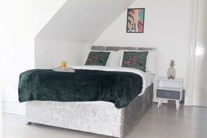 A bedroom with a bed, pillows, a bedside table, and a wall art piece. - En-Suite Room near University of Aberdeen (Aberdeen)