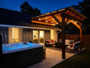 A hot tub in a covered outdoor area with a patio and seating.