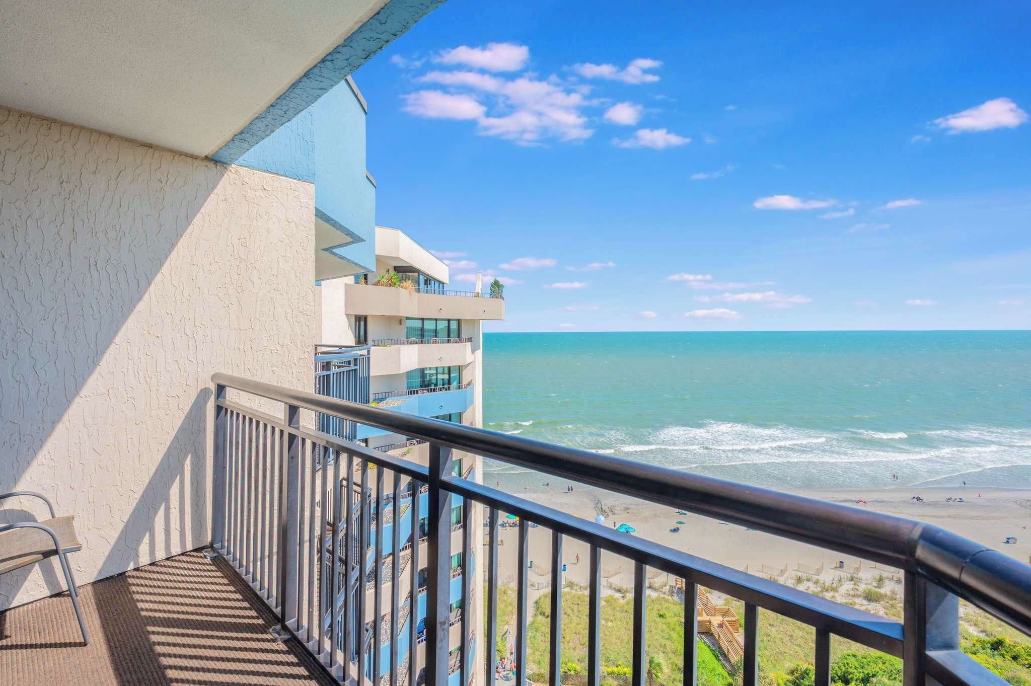 A balcony with a view of the ocean and beach.