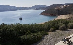 A coastal landscape with a boat on the water, a beach, and a view of hills. - Villa Lioren, Divine Sea Views, Private Pool, Furnished Terrace, Mykonos (Mykonos)