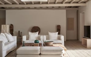 A minimalist living room with a sofa set, a coffee table, and a television. - Villa Lioren, Divine Sea Views, Private Pool, Furnished Terrace, Mykonos (Mykonos)