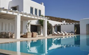 A modern pool area with lounge chairs, a pergola, and a clear blue pool. - Villa Lioren, Divine Sea Views, Private Pool, Furnished Terrace, Mykonos (Mykonos)