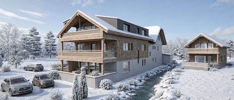 A modern two-story lodge with a balcony, a wooden facade, and a snow-covered landscape.