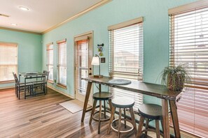 A room with a dining table, chairs, a bar stool, and a potted plant. - Walk to Crystal Beach - Family Retreat (Bolivar Peninsula)
