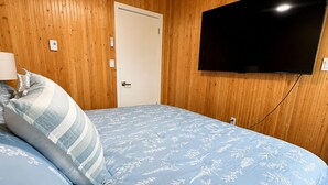 A bedroom with a bed, a television mounted on the wall, and a wooden ceiling. - Hydrangeas at Stanley Bridge #4 (Breadalbane)