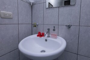 Ein Badezimmer mit Waschbecken, Spiegel und einer Steckdose.