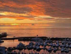 Ein Yachthafen mit vertäuten Booten, einer Anlegestelle und einem Sonnenuntergang über dem Wasser.