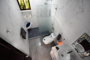 Ein Badezimmer mit Duschkabine, Toilette und Waschbecken.