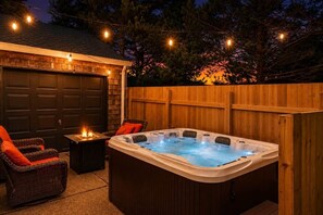 A hot tub with a wooden deck, a garage, and outdoor seating. - Sonny At The Coast (Cloverdale)