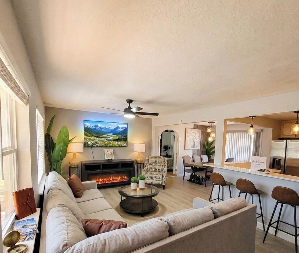 Ein modernes Wohnzimmer mit einer Couch, einem Couchtisch und einem Flachbildfernseher.