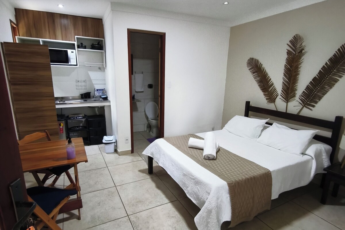 Ein Hotelzimmer mit Bett, Schreibtisch, Stuhl, einer Mikrowelle und einem Badezimmer.