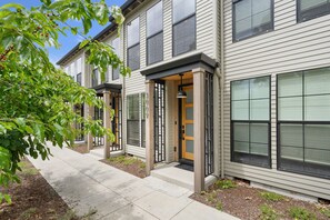 A row of townhouses with a covered walkway, large windows, and a tree with green leaves. - Your Portland Chapter Starts Here, 2 Ensuites (Portland)