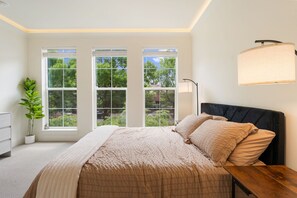 A bedroom with a bed, a nightstand, a lamp, and a potted plant. - Your Portland Chapter Starts Here, 2 Ensuites (Portland)