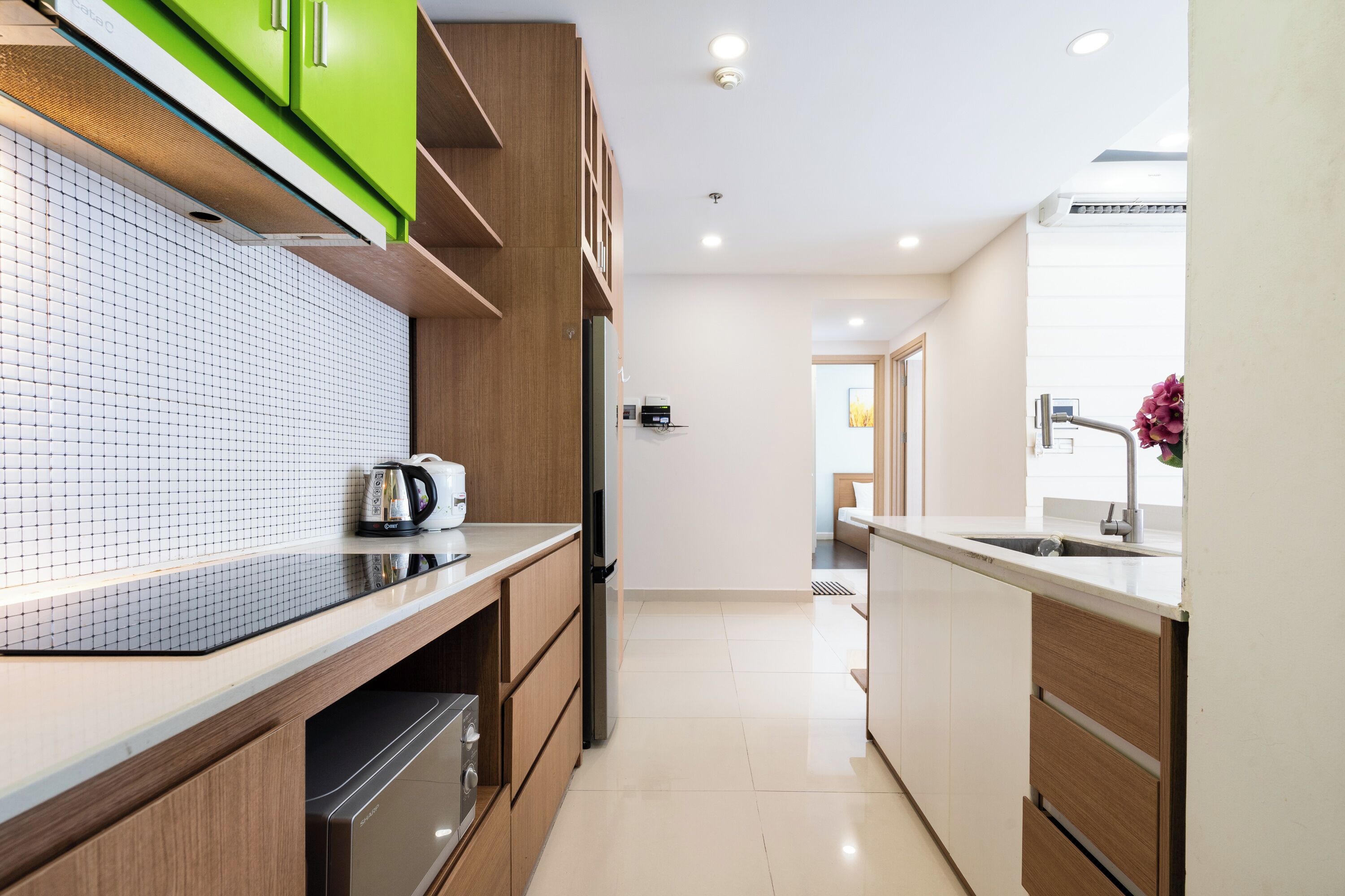 A modern kitchen with wooden cabinets, a tiled backsplash, and a stainless steel range hood.