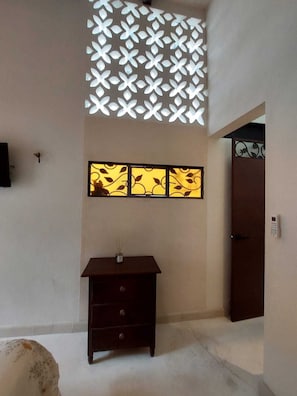 A room with a dark wooden dresser, a wall-mounted light fixture, and a door. - Beautiful apartment with a pool and VIP area on Paseo Montejo in Mérida, Yucatán (Mérida)