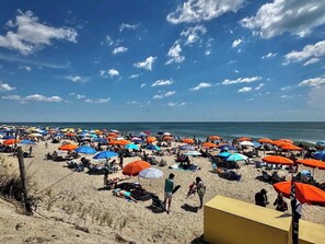 Ein Strand mit vielen Sonnenschirmen und Menschen.
