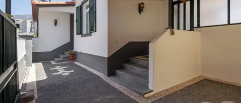 Un espacio al aire libre cubierto con una escalera que lleva a la entrada de un edificio.