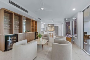 A modern kitchen with wooden cabinets and a built-in dishwasher. - Airlie Views Luxe Escape  - Ocean Views and Pool (Airlie Beach)