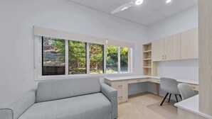 Une chambre moderne équipée d’un bureau, d’une chaise et d’un canapé.