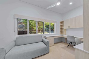 Ein modernes Zimmer mit Schreibtisch, Stuhl und Sofa.