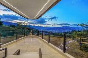 Una terraza panorámica moderna con vistas a la ciudad, barandilla curva y cielo despejado.