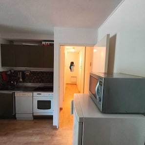 A kitchen with a microwave, oven, and dishwasher. - Appart 3 chambres avec balcon – Résidence de l’Ubaye, Le Sauze (Le Sauze)