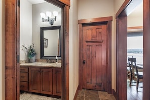 A wooden door with a mirror and a light fixture above it. - Sandy Beach Lodge | Lakefront Luxury | 30min to YNP (Island Park)