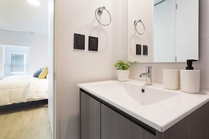 Standaard appartement | Badkamer | Een bad/douchecombinatie, een haardroger, handdoeken, zeep